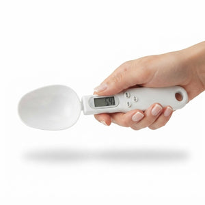 Hand holding digital kitchen measuring spoon scale with LCD display