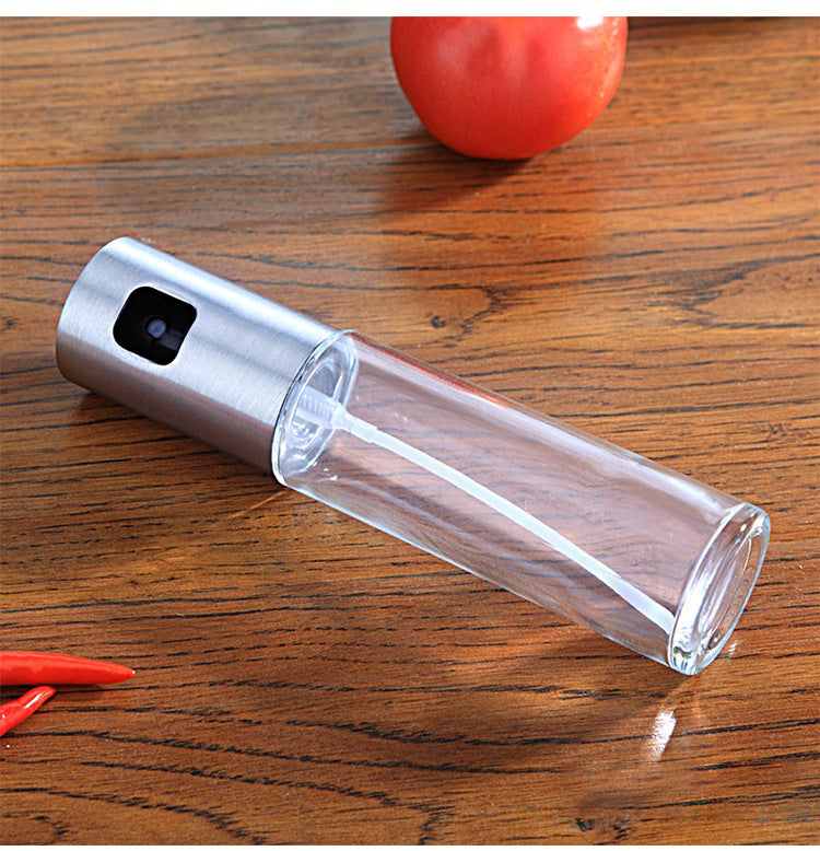 Clear spray bottle with silver top on a wooden surface