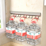 Three large water bottles with red labels hanging on a wall-mounted hook rack.