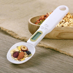 Digital kitchen scale with a white bowl on a white background