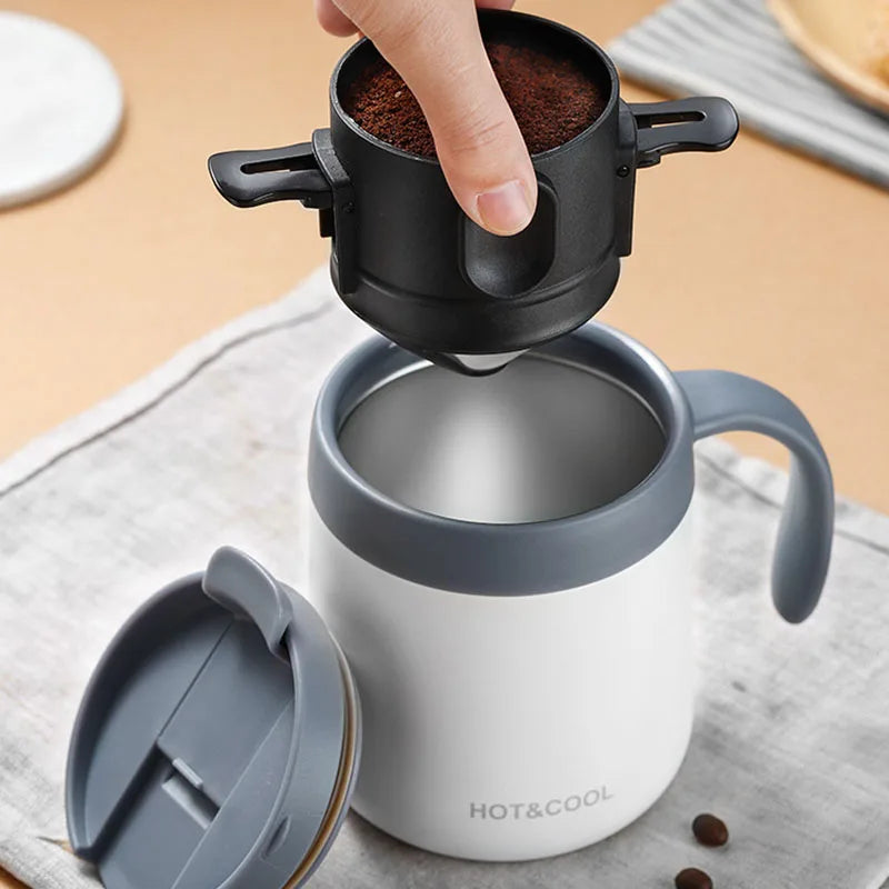 Coffee maker with a hand adding coffee grounds on a wooden surface