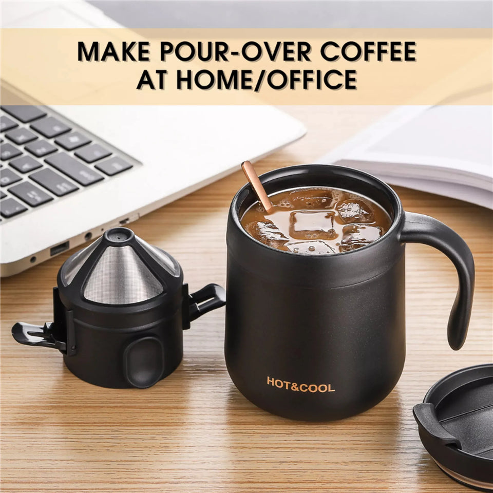 Black coffee maker with a mug on a desk next to a laptop